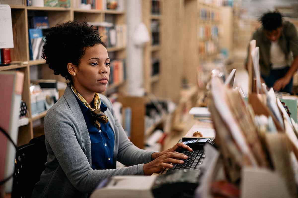 a librarian sitting at a desk typing on a computer