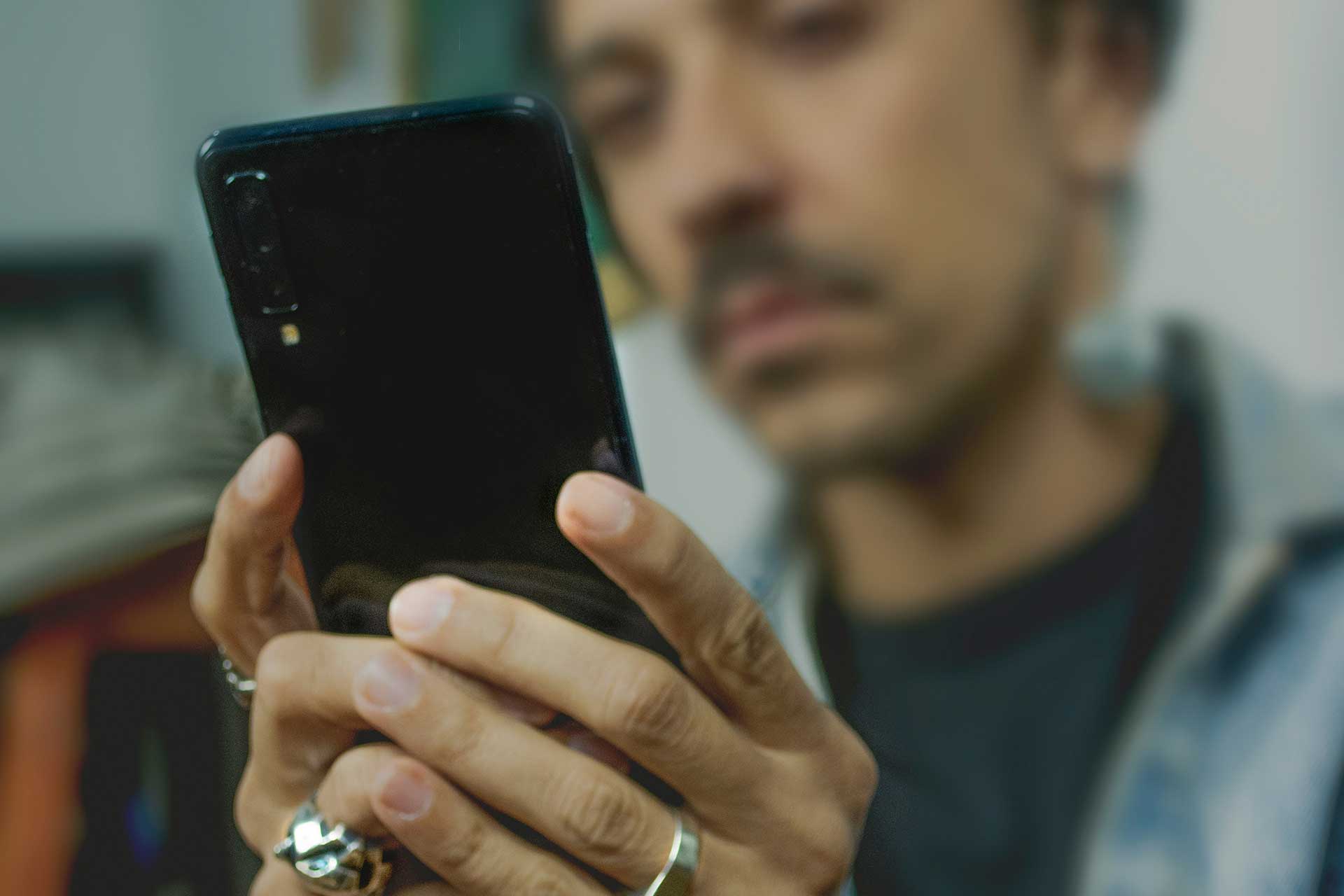 Person holding smartphone with rings using comments layer